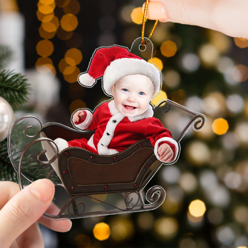Personalized baby photo ornament featuring a baby in Santa outfit in a decorative sleigh for holiday decor