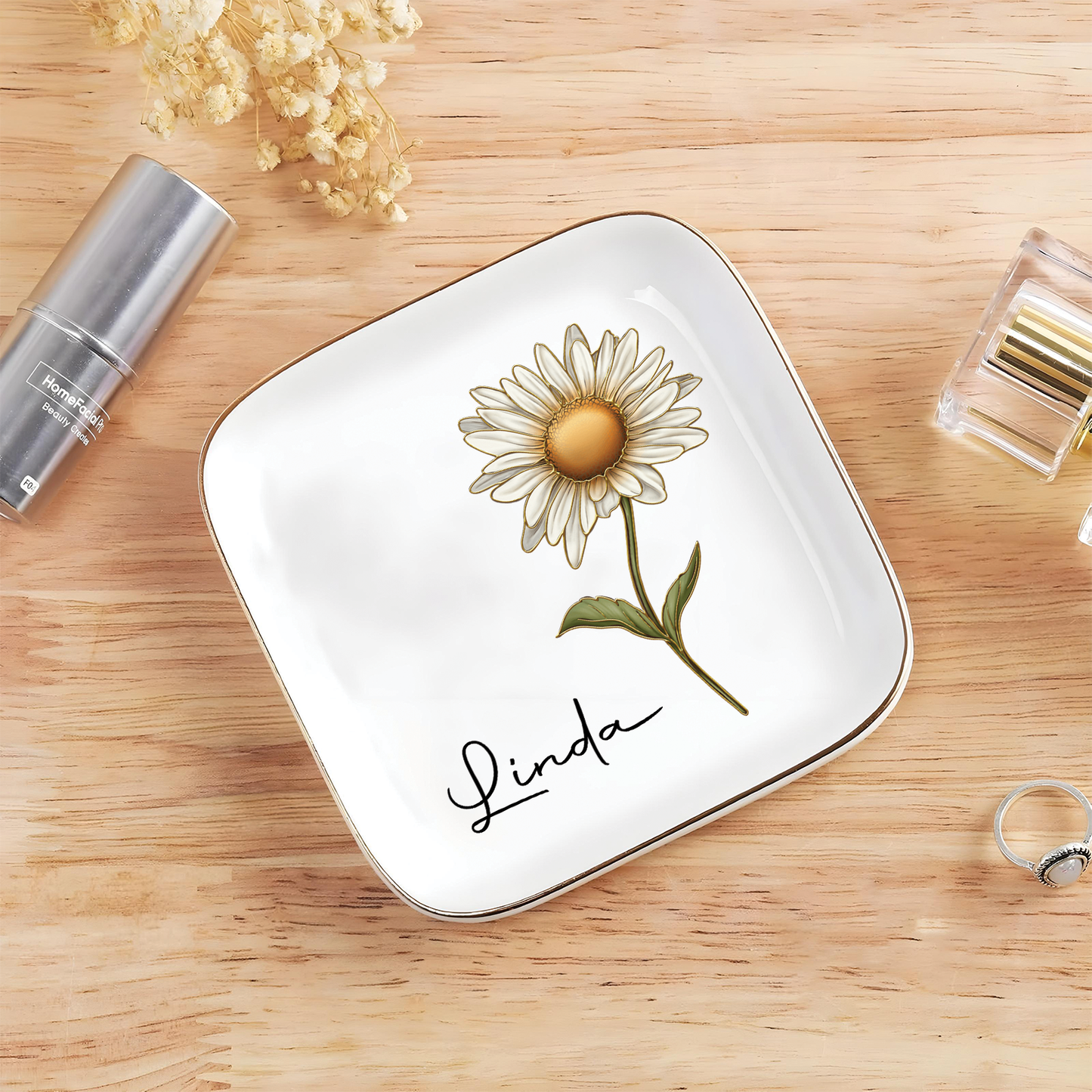 Personalized birth month flower jewelry dish featuring a daisy with the name Linda