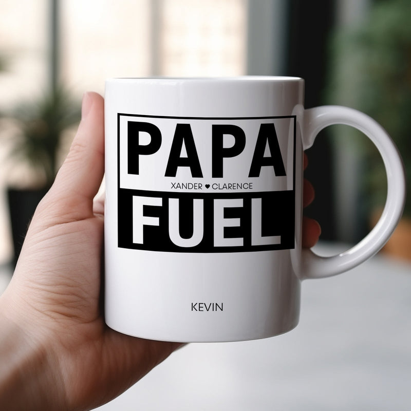 White ceramic personalized dad mug reading PAPA FUEL with custom name Kevin held in hand