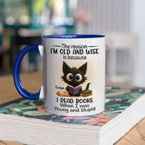 funny personalized accent mug for bookworms featuring a cute black kitten reading a book on white mug with blue handle
