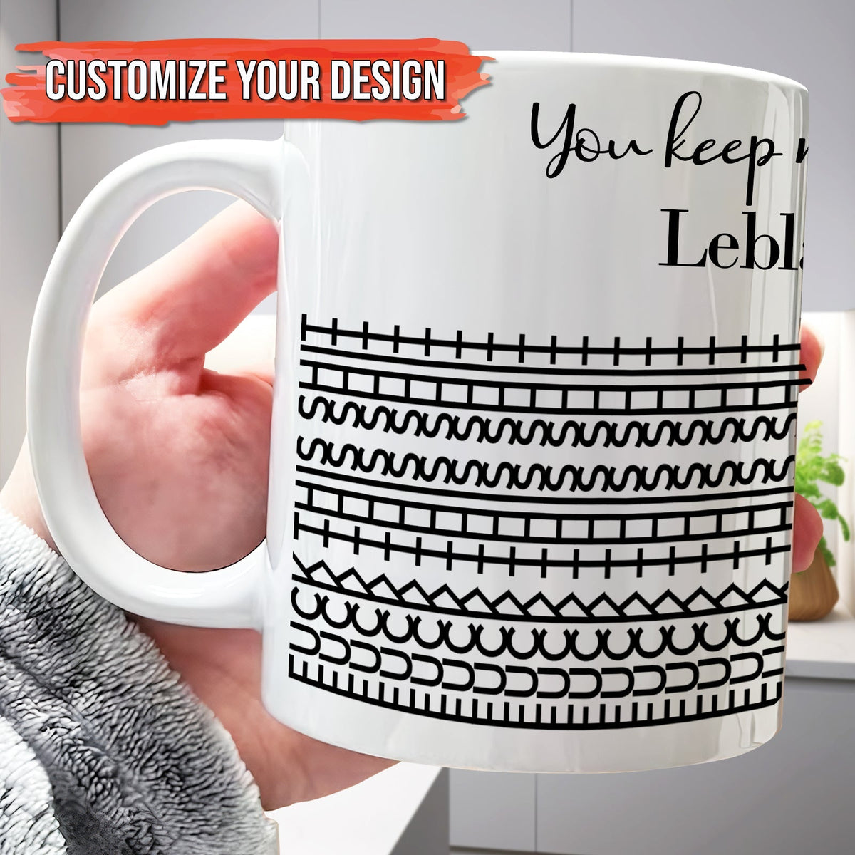 Hand holding 365Gifty white ceramic personalized 'You Keep Me Sane' mug with black geometric stripe pattern