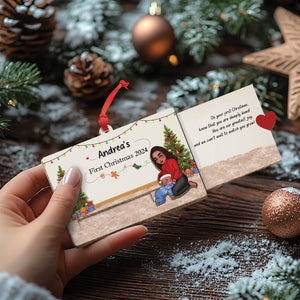Hand holding custom wooden Christmas slider card with holiday design and personalized text for Andrea's first Christmas 2024