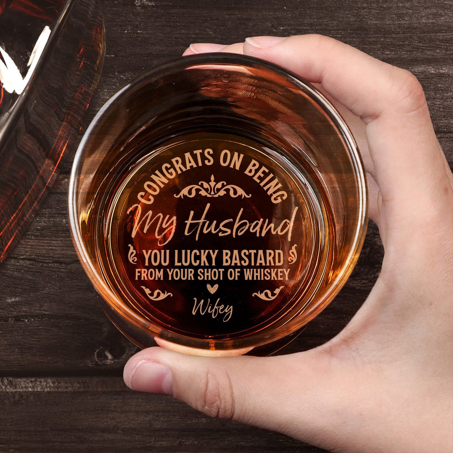 Top view of a Personalized Whiskey Glass held in hand engraved with congrats on being my husband message from wifey