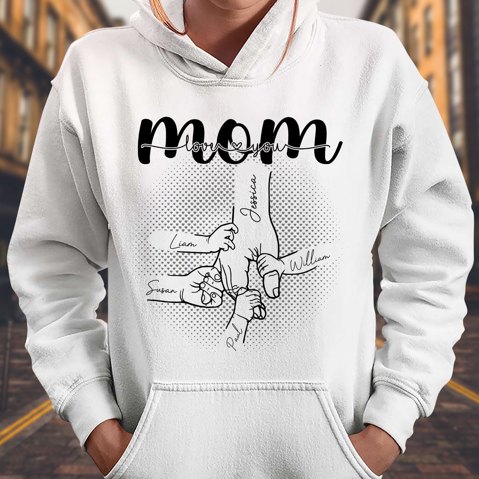 White hoodie featuring 'a mother's love is forever shirt' with hand drawings and names for moms