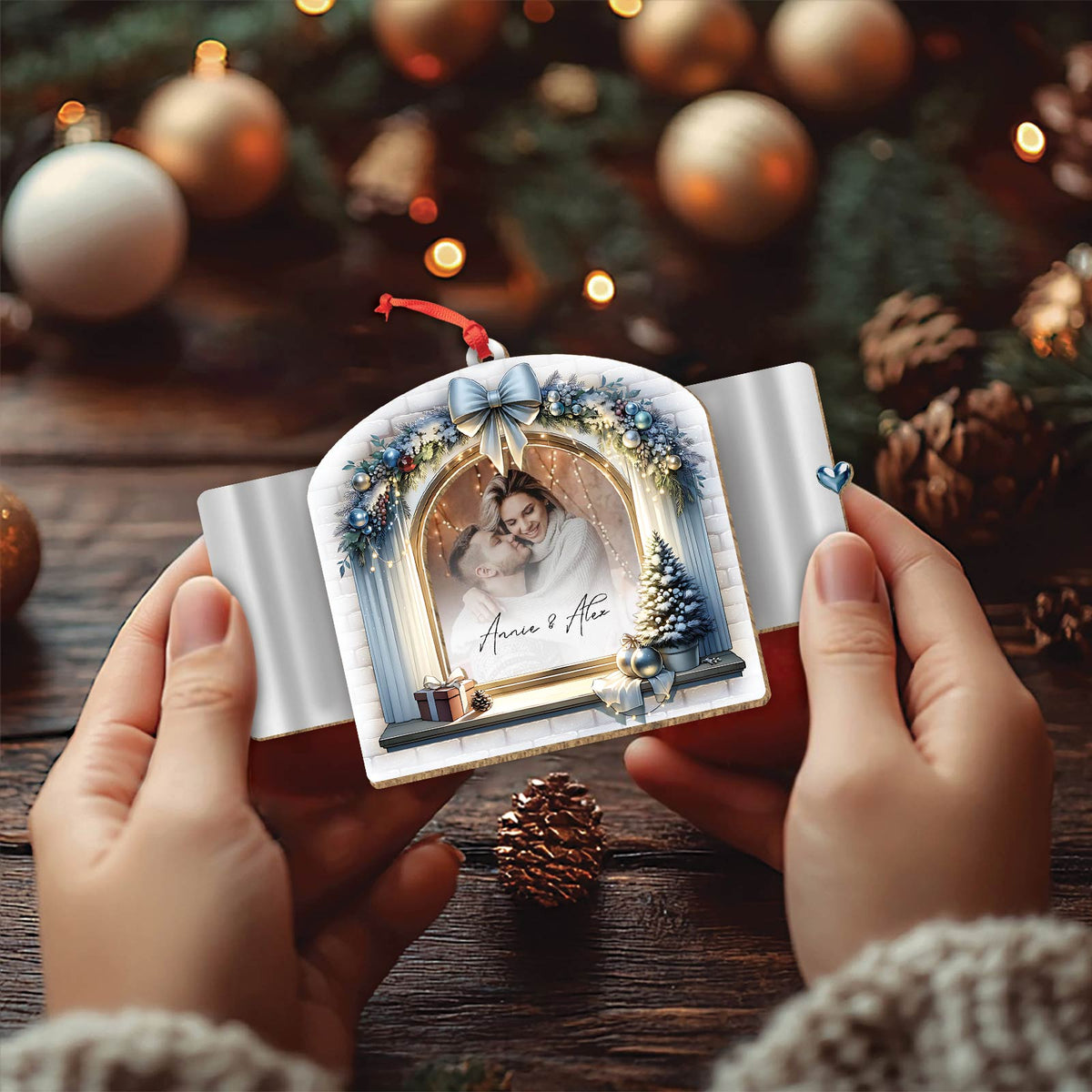 Hands holding a personalized Christmas ornament with a photo and names on a festive decorated background
