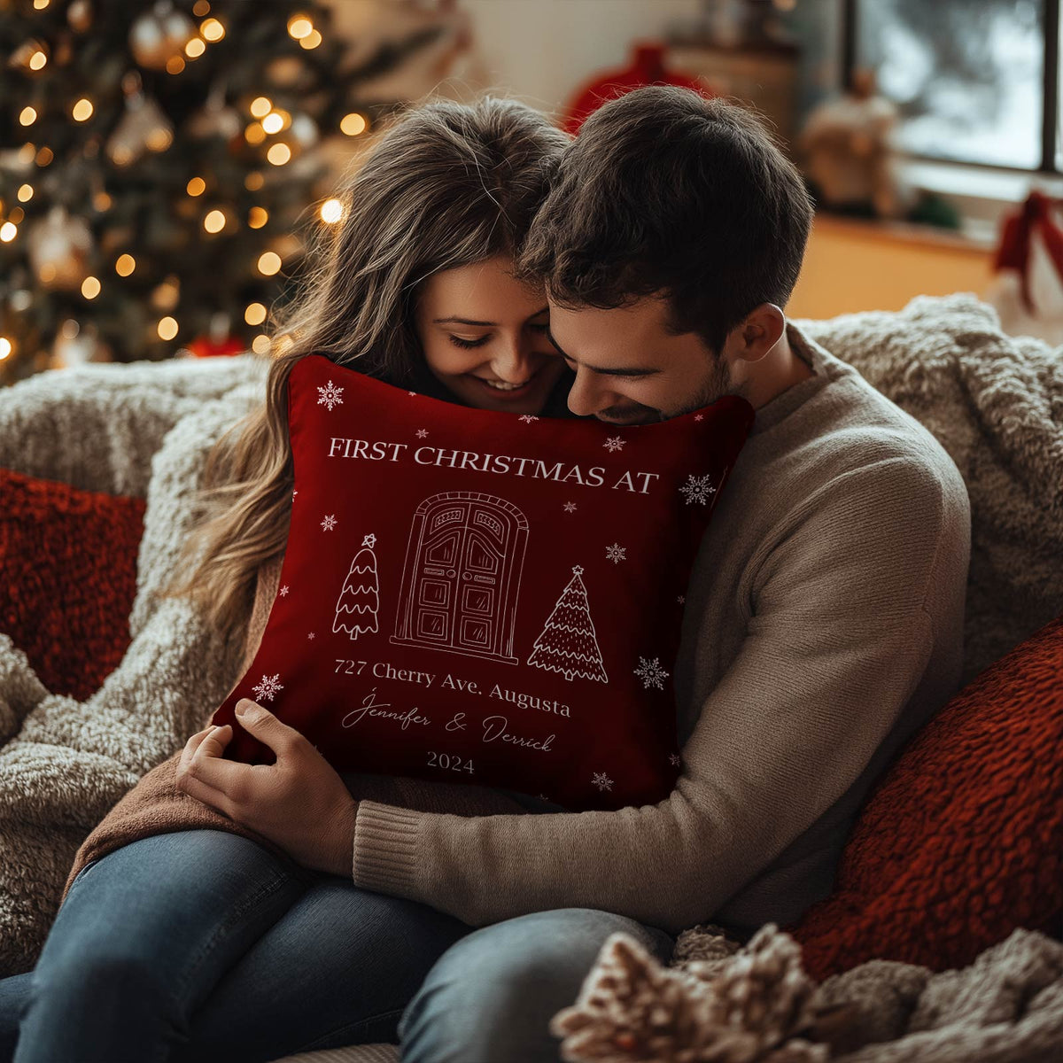 Couple cozying on couch holding personalized couple Christmas pillow with festive door design