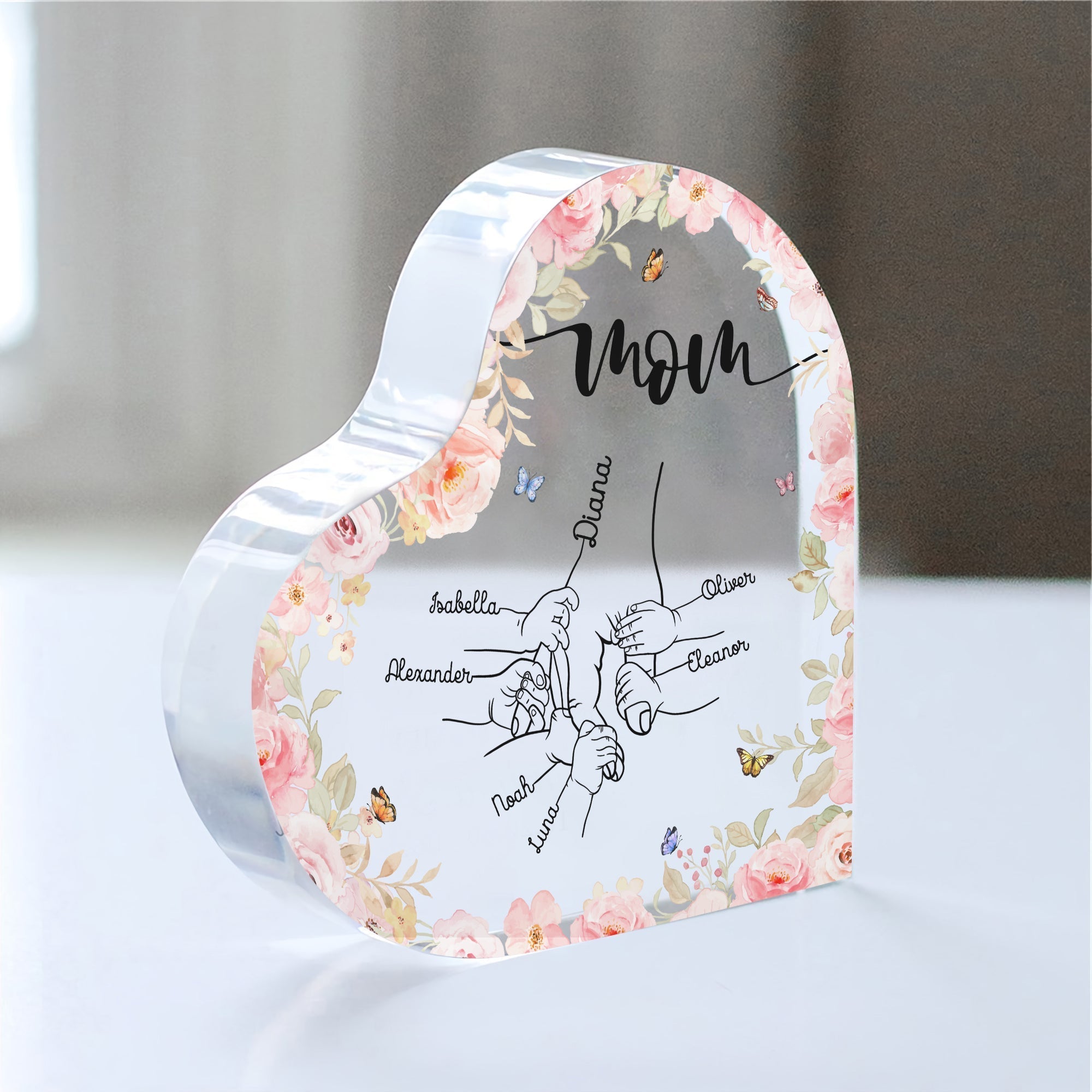 Personalized mom acrylic plaque with floral design and family names engraved on a heart-shaped base