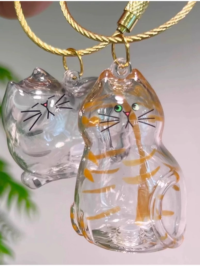 Two adorable glass cat ornaments as personalized pet keepsake gifts with playful designs