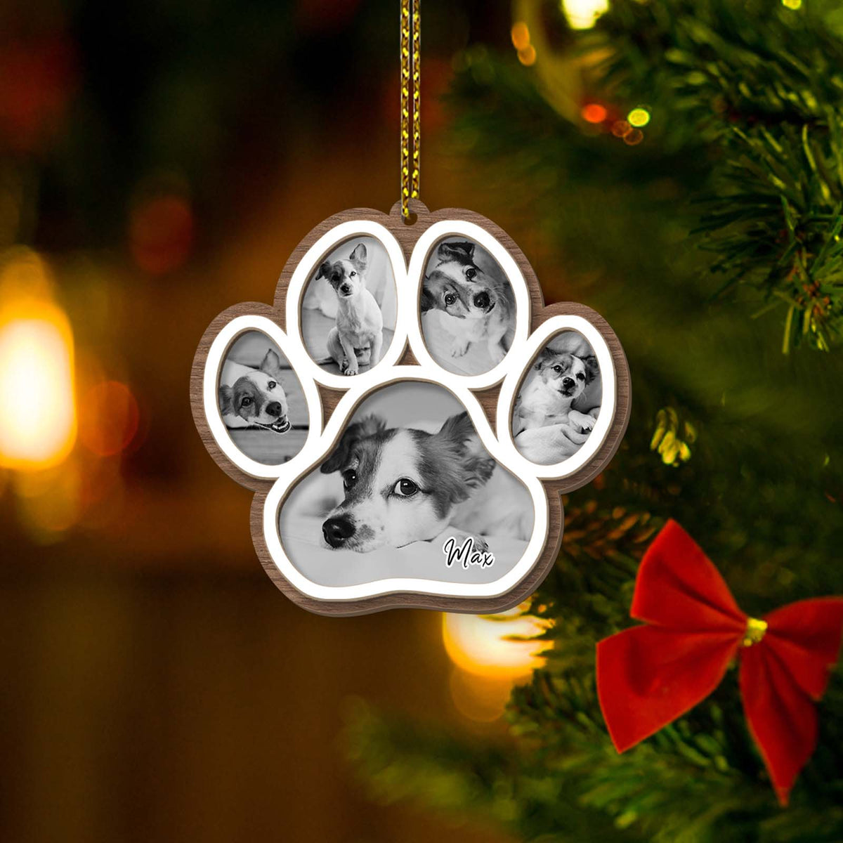 Paw shaped wooden personalized dog memorial ornament with five photo frames showing a small dog hanging on a Christmas tree