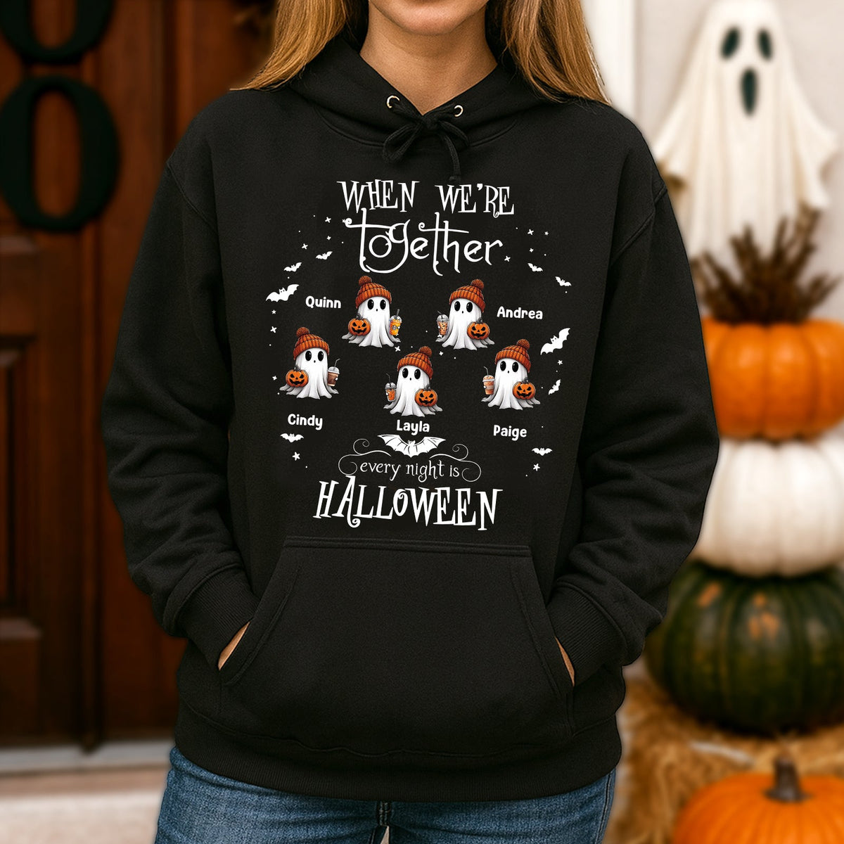 Black hoodie with cute ghost characters holding pumpkins and custom names on a personalized Halloween ghost shirt
