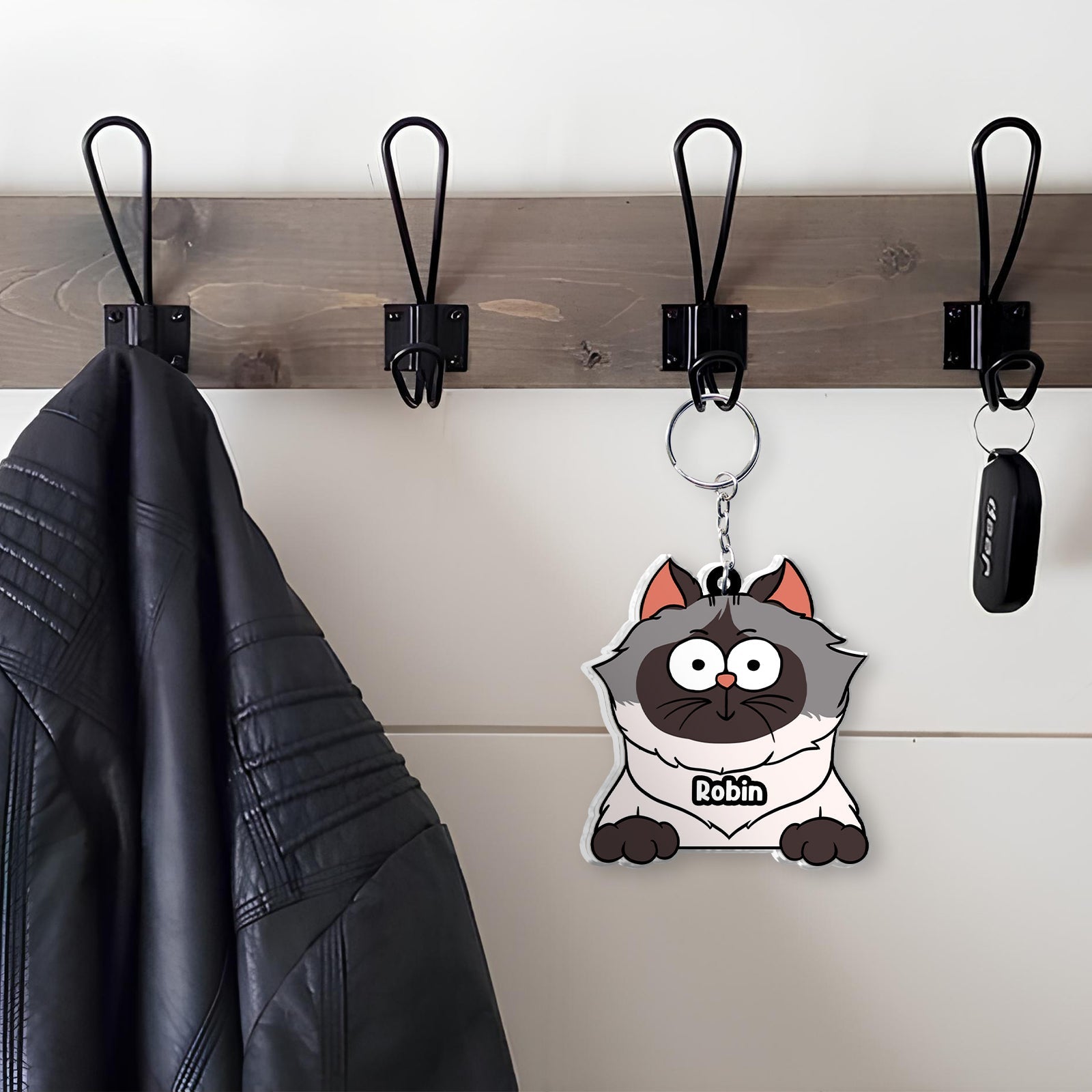 Unique shaking keychain for cat lovers featuring a cute cartoon cat design hanging on a coat hook