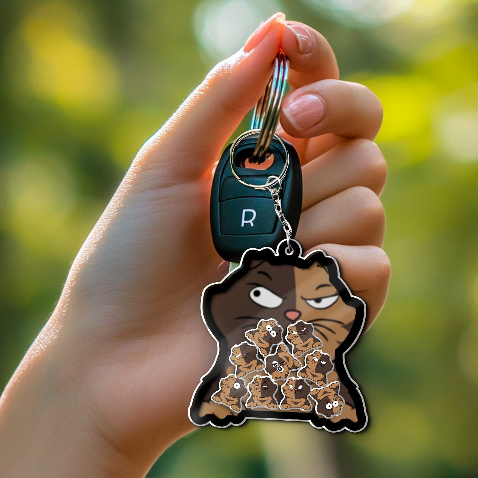 Unique shaking keychain for cat lovers featuring a cartoon cat design holding tiny cats