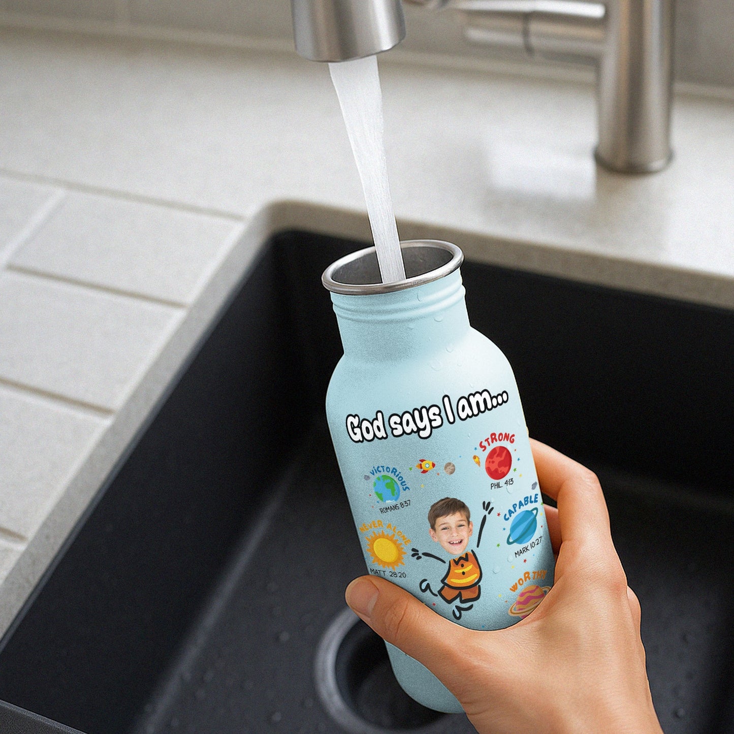 365Gifty blue water bottle for kids with motivational design being filled with water at kitchen sink
