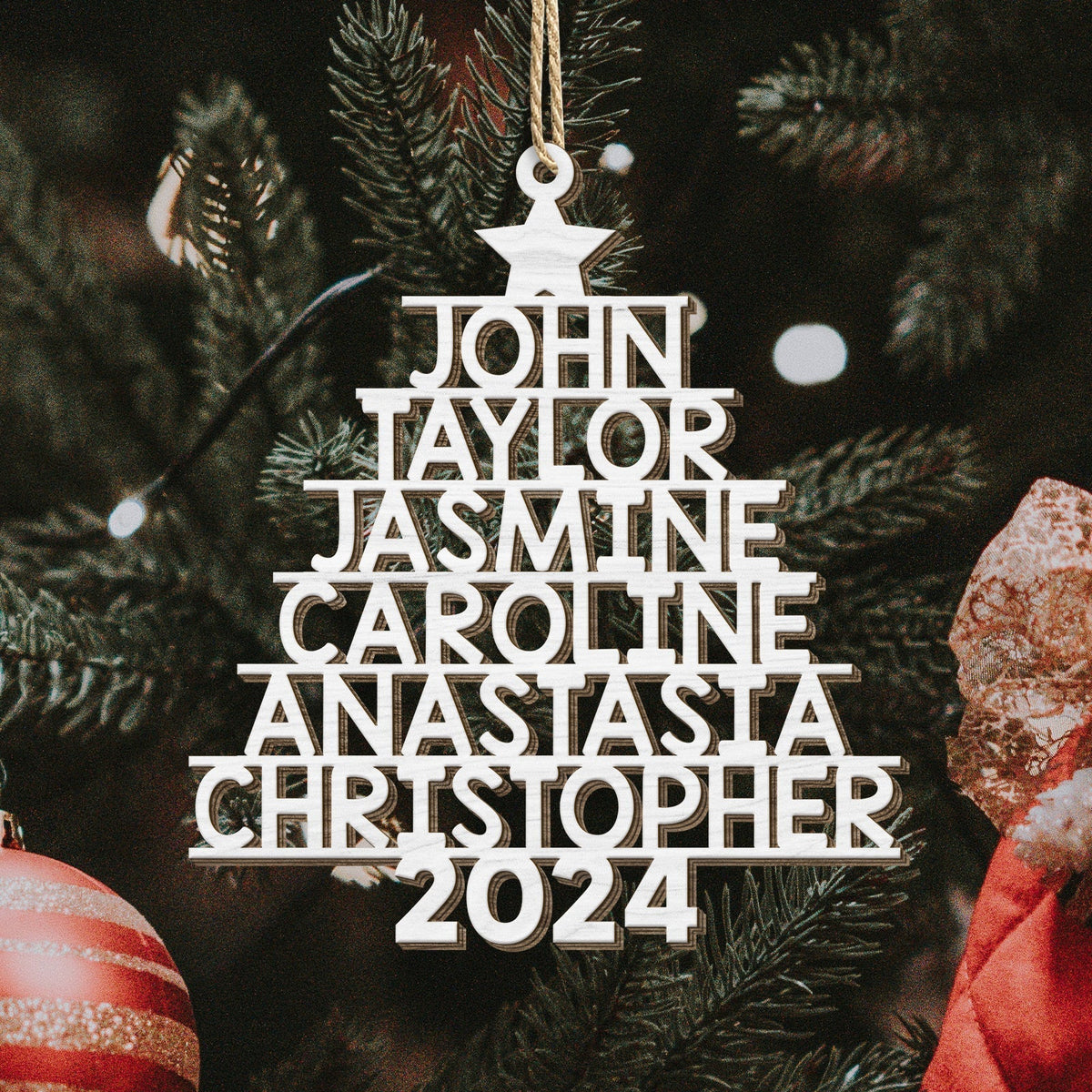 Personalized Christmas tree ornament shaped like a tree with multiple names and 2024 hanging on pine branches